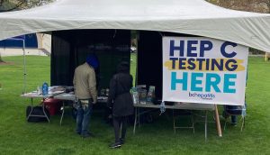 a big white tent with no sides with a banner reading Hep C Testing Here