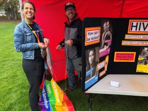 preparing a booth of HIV information and hanging a pride flag